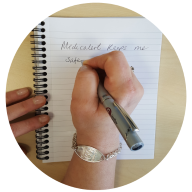 Our member Anne S writing on a notebook wearing her Classic MedicAlert Bracelet in Silver: MedicAlert for Alzheimer's & Hypertension