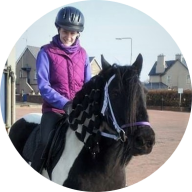 Our member Mandy Elder smiling and riding on a horse: MedicAlert for Chronic Neuropathic Nerve Damage