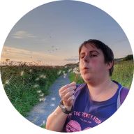Our member Carolyn Smith blowing a dandelion and wearing her MedicAlert Sports Band: MedicAlert for Vascular Ehlers-Danlos Syndrome