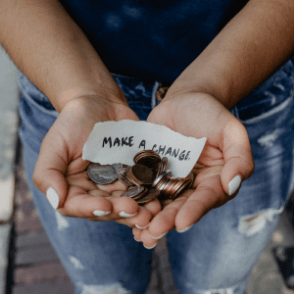Woman with her hands open full of coins and a note saying 'make a change'