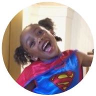 Our member Maya laughing and wearing a Superman costume: MedicAlert for T1 Diabetes, Allergies