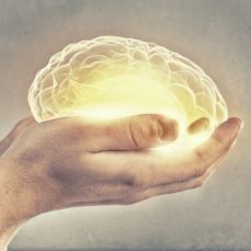 Glowing brain placed in someone's hand