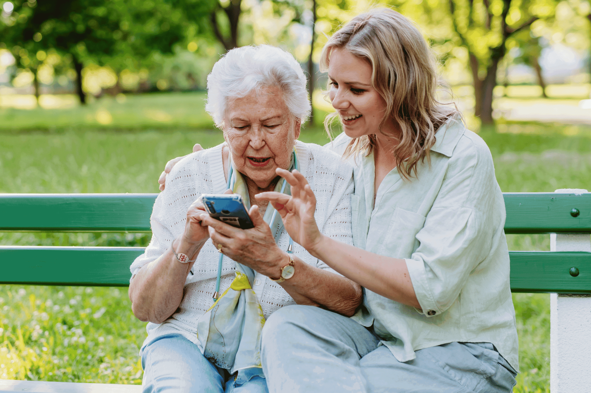 Grandmother wearing a medical ID bracelet sitting in the park with her granddaughter