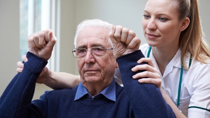 A stroke patient is receiving treatment from a physiotherapist