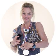 Our member Charlotte Gee smiling, holding her sports trophies/medals and wearing her MedicAlert Sports Band: MedicAlert for Addison's disease