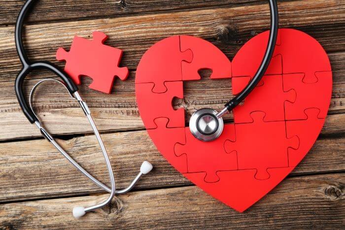 A stethoscope on a jigsaw heart with a piece missing