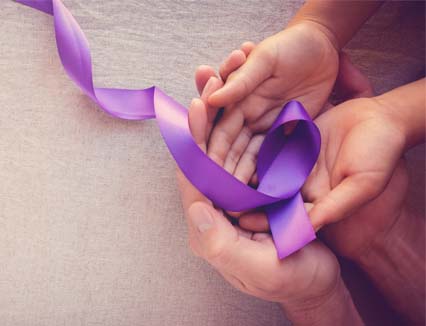 Parent and child holding a purple ribbon together to spread awareness for the Jon Shaw Foundation