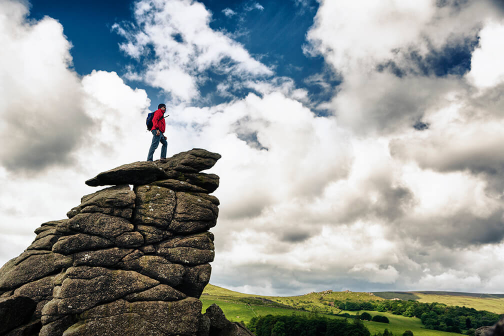 Man stood on top of a rocky mound