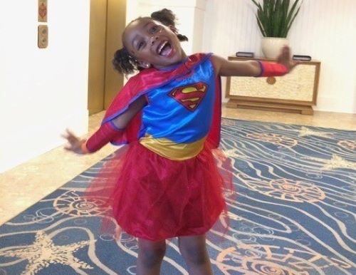MedicAlert member Maya smiling in her Superman custome