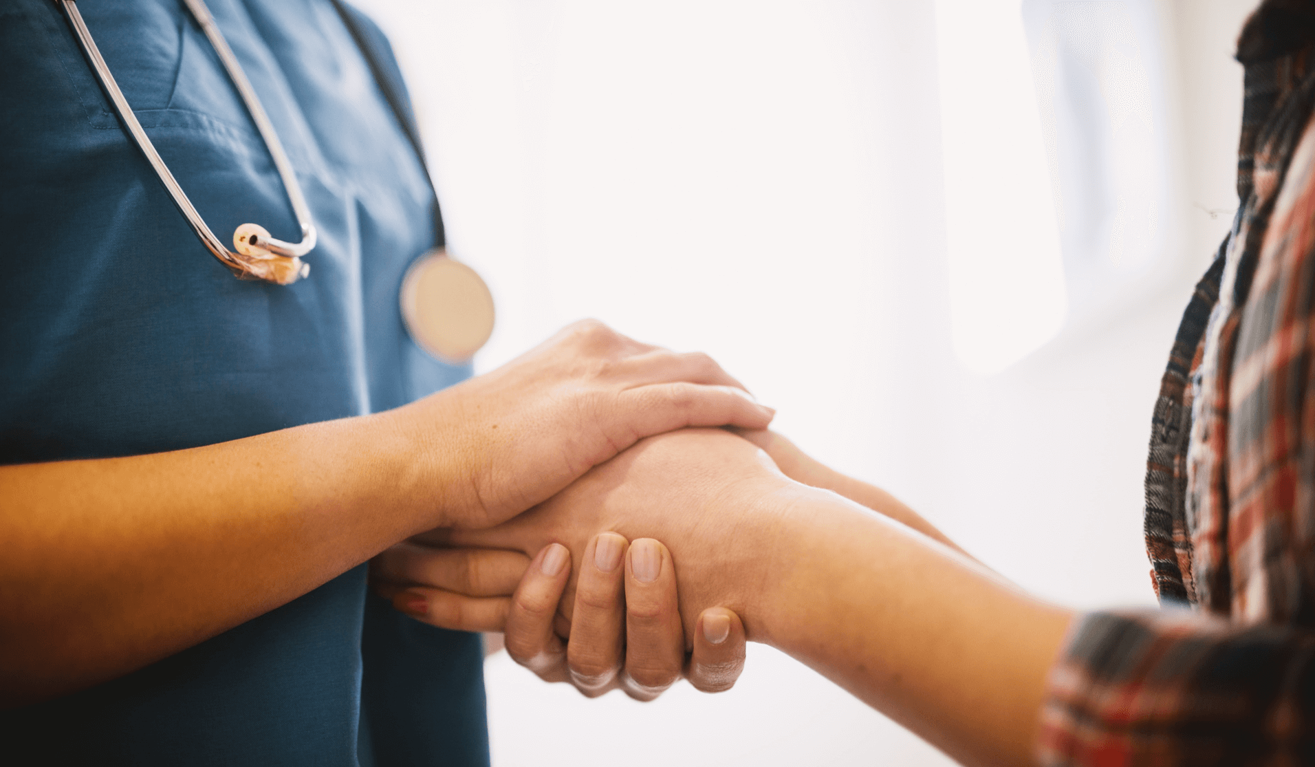 Nurse holding a patient's hand