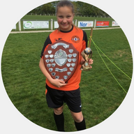 Our member Tilly-Rose Dade smiling and holding her football trophies at the end of her football match: MedicAlert for T1 Diabetes