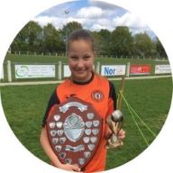 Our member Tilly-Rose Dade smiling and holding her football trophies at the end of her football match: MedicAlert for T1 Diabetes