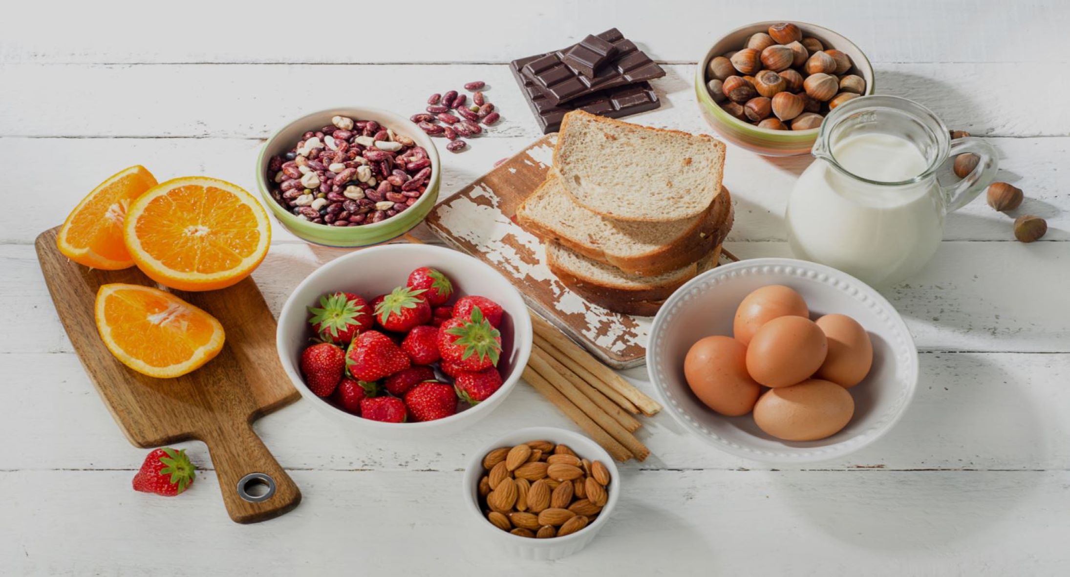 A spread of fruit, nuts, breads, eggs, milk and chocolate