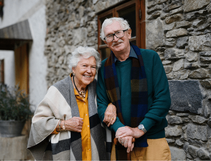An older couple with their arms linked smiling